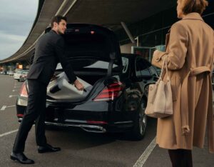 Houston one-way limousine transfer at Hobby Airport with professional chauffeur assisting passenger