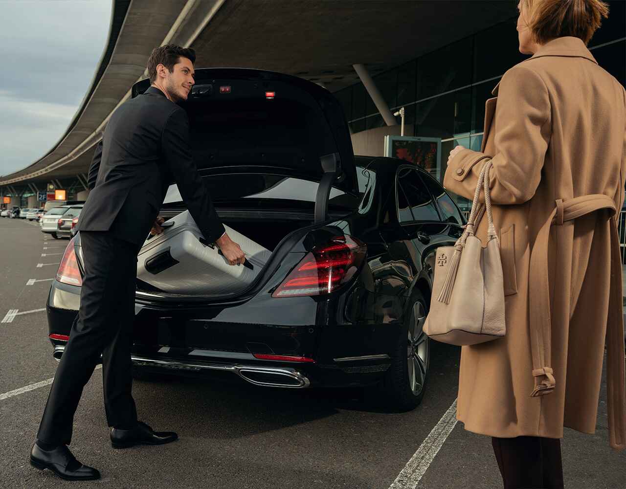 Houston one-way limousine transfer at Hobby Airport with professional chauffeur assisting passenger