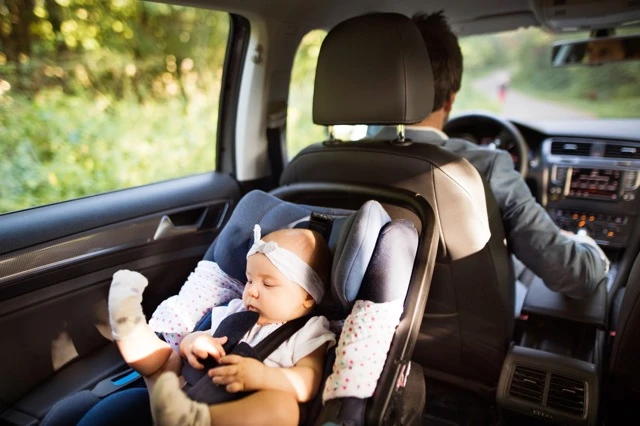 Toddler safely secured in a car seat during Houston car service with car seats for safe family travel