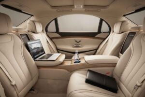 Mercedes S-Class rear cabin interior showing executive productivity setup with laptop for Houston to Austin business travel